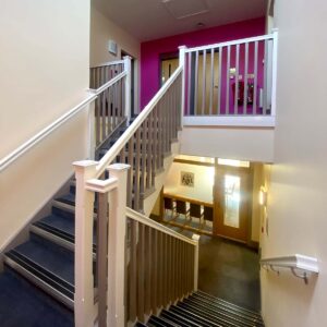 A view of the stairwell in The Hollies, with bannisters and railing.