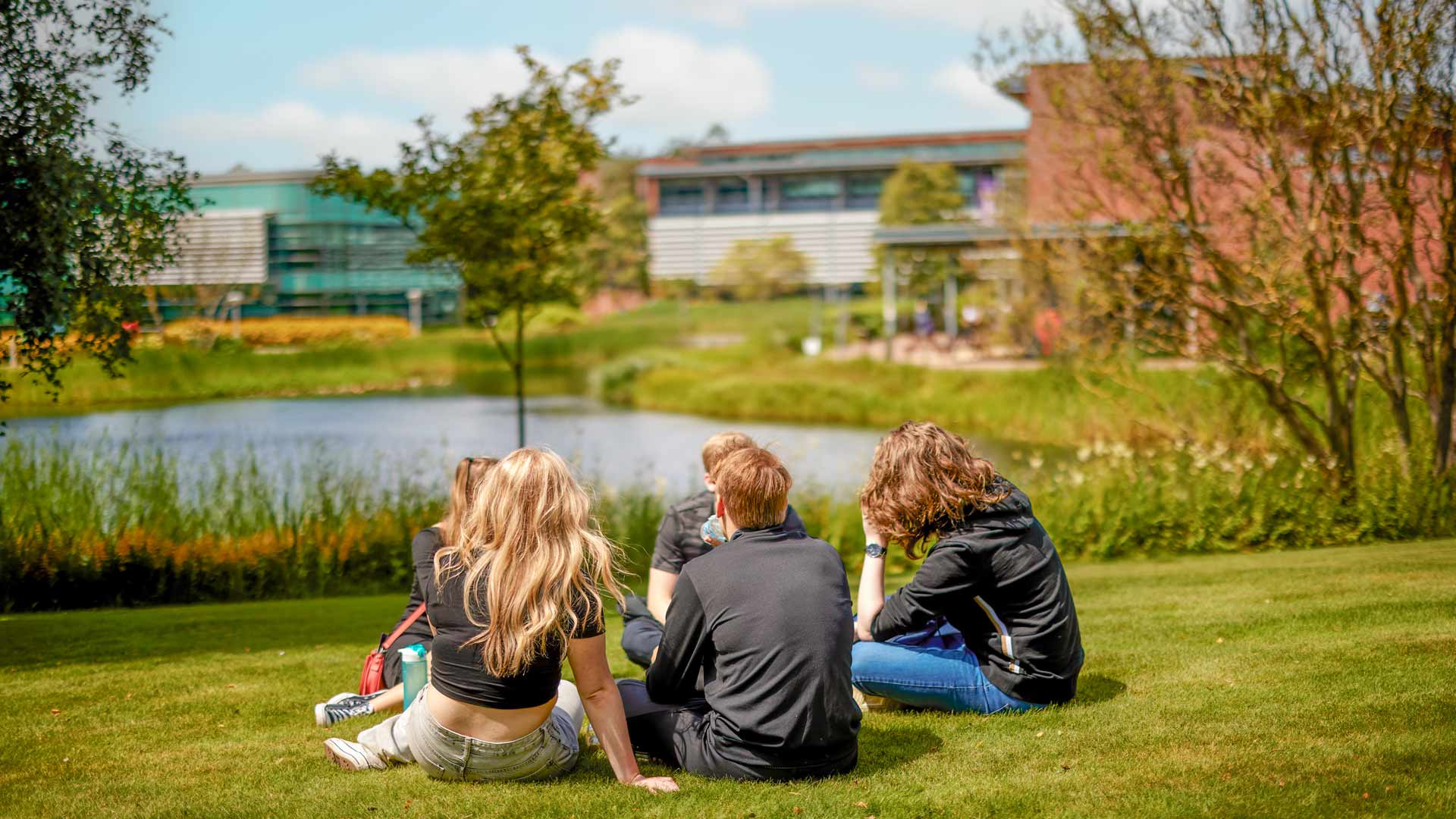 Students sitting on the grass on campus